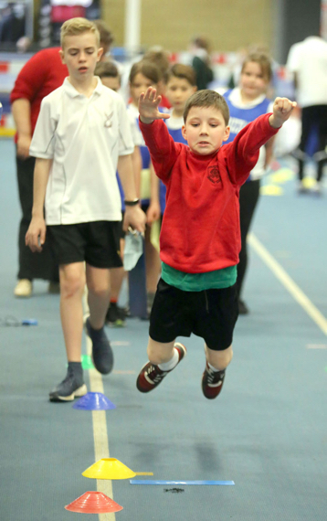 Young pupil leaps during long jump activity